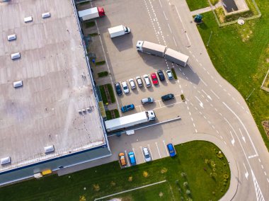 Malzeme deposunun havadan görüntüsü. Sanayi bölgesindeki lojistik merkezi yukarıdan. Lojistik merkez stok fotoğrafına yüklenen kamyonların hava görüntüsü