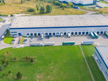 Malzeme deposunun havadan görüntüsü. Sanayi bölgesindeki lojistik merkezi yukarıdan. Lojistik merkez stok fotoğrafına yüklenen kamyonların hava görüntüsü