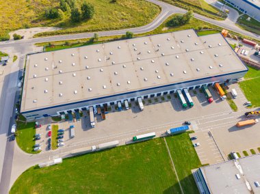 Çatıda güneş panelleri olan modern deponun hava görüntüsü. Endüstriyel şehir bölgesindeki lojistik merkezi İHA 'nın gözünden. Arkaplan dokusu kavramı.