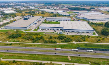 Çatıda güneş panelleri olan modern deponun hava görüntüsü. Endüstriyel şehir bölgesindeki lojistik merkezi İHA 'nın gözünden. Arkaplan dokusu kavramı.