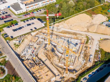 İkamet binası yapım aşamasında. Turnalar ve diğer inşaat makineleri yeşil bir mahallede inşa edilen yeni binayı çevreledi.