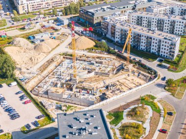 yapım aşamasında yeni modern apartman havadan üst görünümü. şantiyede çalışan sarı vinçler