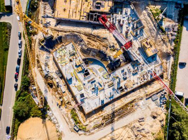 Çok katlı yeni binaların inşaatı. Şafak vakti inşaat vinci bir inşaat sahasında. İnsansız hava aracının görüntüsü. Sabah sisi ufukta.