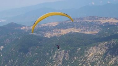 Paragliderler destansı bir manzarayla dağın tepesinden uçarlar. Paraşüt ya da yamaç paraşütü tecrübesi. Adrenalin ve aşırı spor. Doğada sakin ve sakin bir zaman.