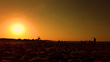 Cankurtaran Kulesi Sunset tarafından siluetlendi. Yürüyen insanlar. plaj