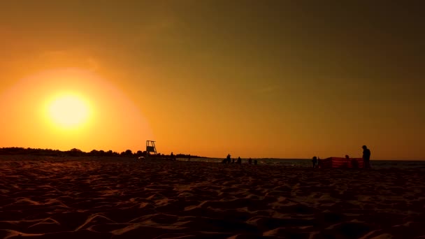 Tour de sauveteur Silhouette par le coucher du soleil. Les gens marchent. plage — Video
