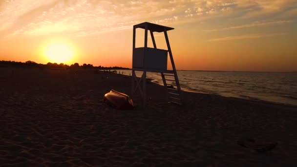 Śródziemnomorska plaża z drewnianym krzesłem ratownika w czasie zachodu słońca, — Wideo stockowe