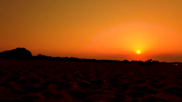 Hermoso lapso de tiempo 4k puesta de sol en una playa con una torre de salvavidas en primer plano y la puesta de sol en el fondo — Vídeo de stock