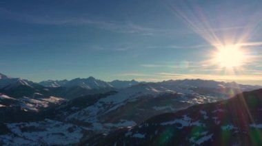 Dağlarda Günbatımında Altın Güneş Işığı. Güzel güneşli bir akşam. Kış Dağları 'nın havadan görünüşü. Güzel Kış Manzarası. Karlı Alp dağlarının üzerinde uçarken.