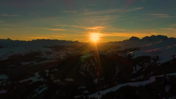 Goldenes Sonnenlicht bei Sonnenuntergang in den Bergen. Schöner sonniger Abend. Luftaufnahme des Wintergebirges. Schöne Winterlandschaft. Fliegen über verschneiten Alpen. — Stockvideo