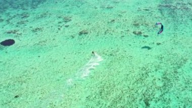 Uçurtma Le Morne, Mauritius. İnsansız hava aracı uçurtma sörfçüsünün önünde geriye doğru uçuyor. Uçurtma sörfçüsü kristal berrak suda sörf yapıyor, mükemmel dalgalar. Hava görünümü