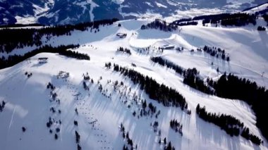 İHA 'dan kayak merkezinde panoramik üst görüntü. Kayak kaldırma asansörü kayakçıları ve snowboardcuları dağ eteklerindeki kar yamacında, bir sürü insan. UHD 4k video