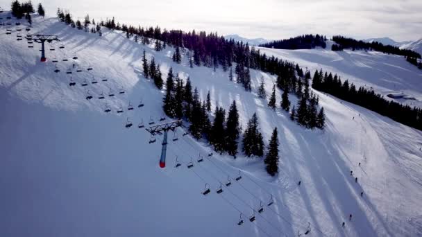 Flygfoto över People Skidåkning och snowboard på kullen, Ski Resort. Drone flyger över Skidåkare Skidåkning ner för backen, Alp berg, — Stockvideo