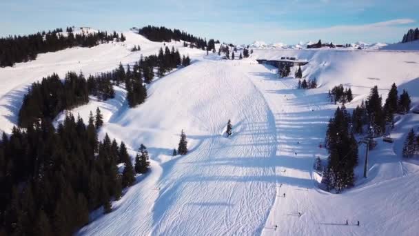 Skieen in de Alpen met de skilift en mensen skiën op de helling. Luchtfoto — Stockvideo