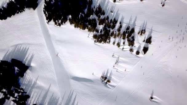 Letecký pohled na lyžování a snowboarding na kopci, Lyžařské středisko. Dron přeletí přes Lyžaře, sjíždí z kopce, Alpy,