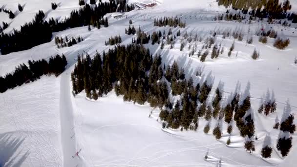 Letecký pohled na lyžování a snowboarding na kopci, Lyžařské středisko. Dron přeletí přes Lyžaře, sjíždí z kopce, Alpy, — Stock video