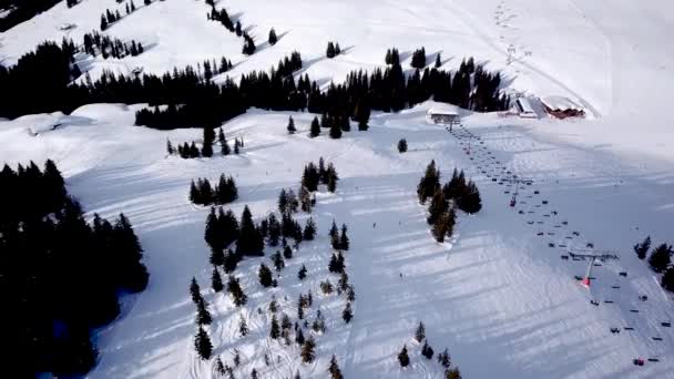 Vista panoramica dall'alto dal drone sulla via cavo nella stazione sciistica. Impianti di risalita che trasportano sciatori e snowboarder su piste invernali innevate in località montana, molte persone. UHD 4k video — Video Stock