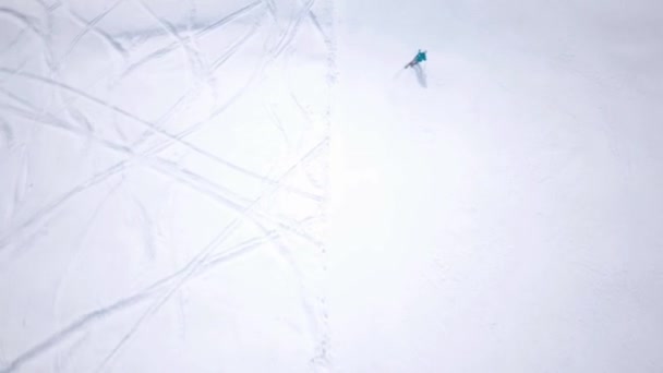 松林と太陽の山のスキーリゾートの空中。リフトで雪の斜面を滑り降りる。冬の自然景観。男性と女性の極端なスポーツ。積極的かつ健康的なライフスタイル。雪のトウヒの木 — ストック動画