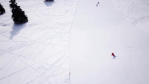Imágenes aéreas 4k, dron siguiendo a esquiadores en pista de esquí en la región de esquí. Esquiadores esquiando cuesta abajo la pista de esquí durante el día de invierno en las altas montañas, vista aérea Alpes — Vídeos de Stock