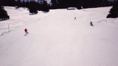 Kayakçılar yokuş aşağı kayıyor kış günü yüksek dağlarda, hava manzaralı yamaçlarda.
