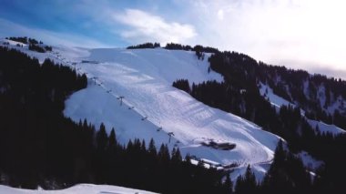 Alçak bulutlarda karlı dağlar ve kışın günbatımında mavi gökyüzü. Panoramik manzara, buzlu bir akşamda sisli kayalarla kaplı güzel karlar. Yüksek tepelerin havadan görünüşü. Dolomitlerde Alpler, İtalya