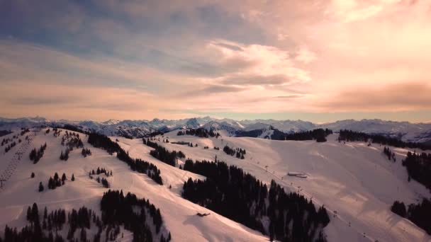 Montagnes enneigées dans les nuages bas et ciel bleu au coucher du soleil en hiver. Paysage panoramique avec de belles roches couvertes de neige dans le brouillard dans la soirée givrée. Vue aérienne de hauts sommets. Alpes à Dolomites, Italie — Video