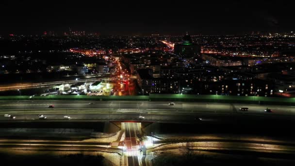 Gece şehir yollarının tepesinde hava manzaralı arabalar var. Geceleri modern gökdelenleri olan şehir manzarası. Görkemli şehir manzarası trafik otobanlı neon fenerlerle aydınlatılıyor. Sinematik araç manzarası — Stok video