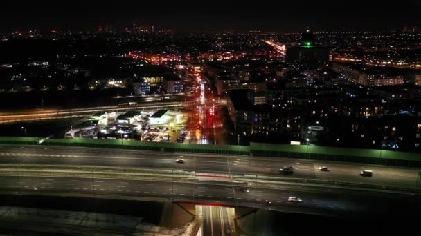 Drone de circulation nocturne sur une autoroute montrant des voitures et des voies lumineuses avec tunnel et viaducs à l'extérieur de la ville de Varsovie, en Pologne. Avancer la caméra. — Video