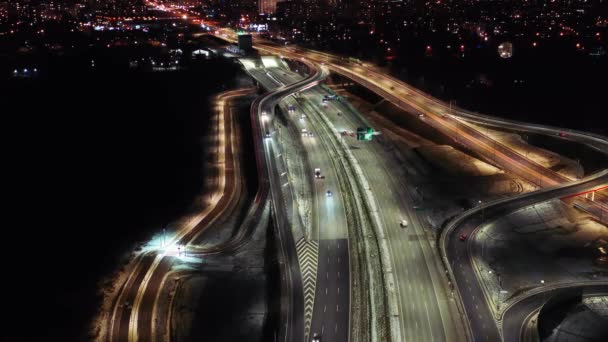 夜の航空フライオーバー交通渋滞インターチェンジ道路、ドローンは、夕方には近代的な都市のビューの道路交差点下のショット。高速道路で忙しい交差点を運転する車の多く — ストック動画