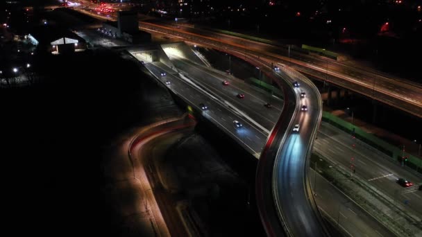 夜の航空フライオーバー交通渋滞インターチェンジ道路、ドローンは、夕方には近代的な都市のビューの道路交差点下のショット。高速道路で忙しい交差点を運転する車の多く — ストック動画