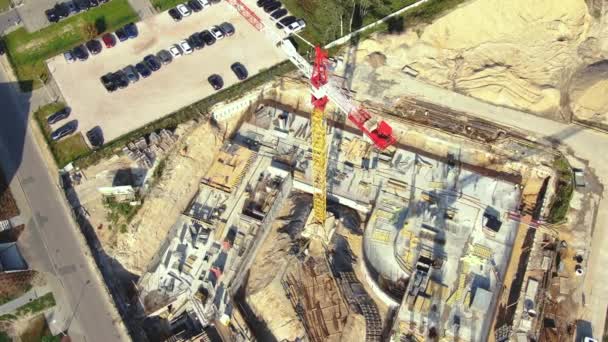 Aerial Flight Over a New Constructions Development Site with High Tower Cranes Building Real Estate. Heavy Machinery and Construction Workers are Employed. Top Down View at Contractors in Safety Hats. — Video Stock