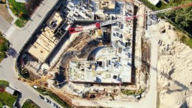 Yüksek inşaat alanı. Arka planda mavi gökyüzü ve şehir manzaralı büyük endüstriyel bir vinç. Beton levhalar ağırlık dengesi. Karşı ağırlık. Hava aracı görüntüsü. Metropolis Şehir Geliştirme