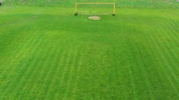 White gate on a football field. Green background of a stadium. Soccer field outdoors. Exterior of sports ground. Camera rising. Aerial view. — Stock Video