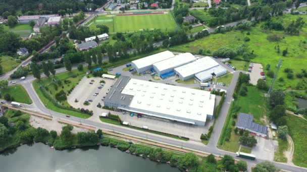 Edifícios do centro logístico, armazéns perto da rodovia, processo de estacionamento de caminhões, vista de altura, um grande número de caminhões no estacionamento perto do armazém. — Vídeo de Stock