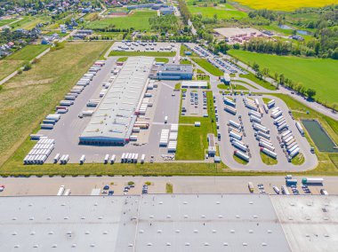 Birçok kamyonun Merchandis 'i boşalttığı Endüstriyel Yükleme Alanının Hava Çekimi