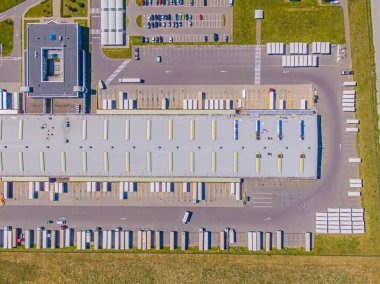 Birçok kamyonun Merchandis 'i boşalttığı Endüstriyel Yükleme Alanının Hava Çekimi