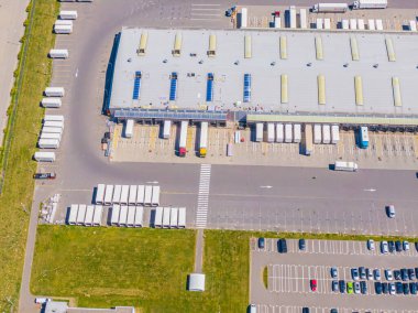 Malzeme deposunun havadan görüntüsü. Sanayi bölgesindeki lojistik merkezi yukarıdan. Lojistik merkezde yüklenen kamyonların hava görüntüsü