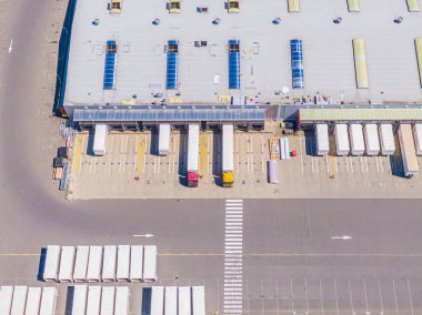 Malzeme deposunun havadan görüntüsü. Sanayi bölgesindeki lojistik merkezi yukarıdan. Lojistik merkezde yüklenen kamyonların hava görüntüsü