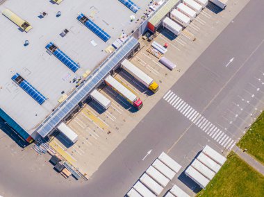 Malzeme deposunun havadan görüntüsü. Sanayi bölgesindeki lojistik merkezi yukarıdan. Lojistik merkezde yüklenen kamyonların hava görüntüsü