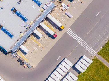 Malzeme deposunun havadan görüntüsü. Sanayi bölgesindeki lojistik merkezi yukarıdan. Lojistik merkezde yüklenen kamyonların hava görüntüsü