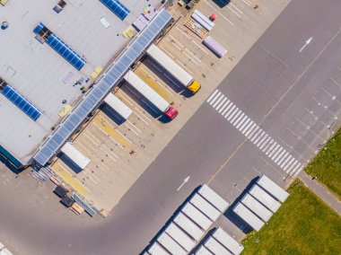 Malzeme deposunun havadan görüntüsü. Sanayi bölgesindeki lojistik merkezi yukarıdan. Lojistik merkezde yüklenen kamyonların hava görüntüsü