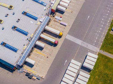 Malzeme deposunun havadan görüntüsü. Sanayi bölgesindeki lojistik merkezi yukarıdan. Lojistik merkezde yüklenen kamyonların hava görüntüsü