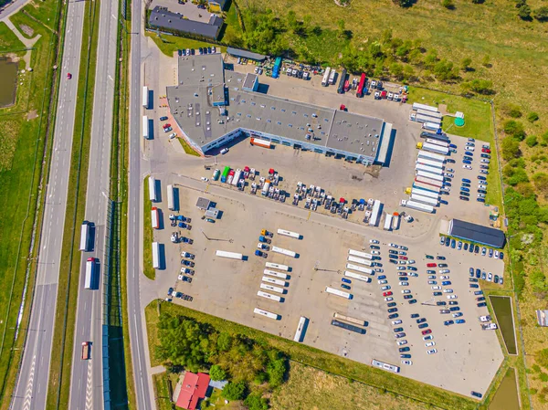 Malzeme deposunun havadan görüntüsü. Sanayi bölgesindeki lojistik merkezi yukarıdan. Lojistik merkezde yüklenen kamyonların hava görüntüsü