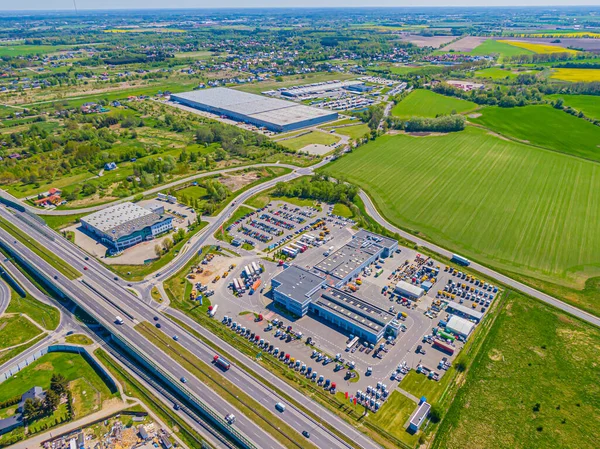 Malzeme deposunun havadan görüntüsü. Sanayi bölgesindeki lojistik merkezi yukarıdan. Lojistik merkezde yüklenen kamyonların hava görüntüsü