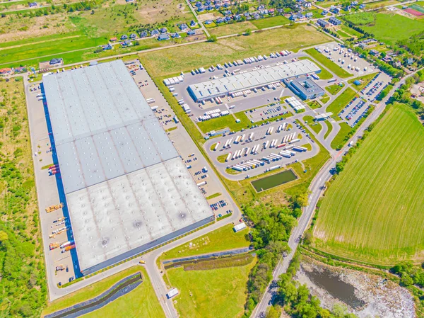 Malzeme deposunun havadan görüntüsü. Sanayi bölgesindeki lojistik merkezi yukarıdan. Lojistik merkezde yüklenen kamyonların hava görüntüsü