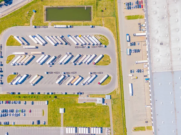 Malzeme deposunun havadan görüntüsü. Sanayi bölgesindeki lojistik merkezi yukarıdan. Lojistik merkezde yüklenen kamyonların hava görüntüsü