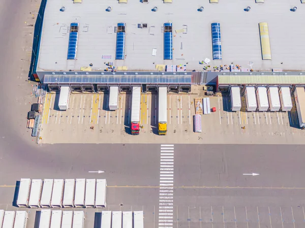 Malzeme deposunun havadan görüntüsü. Sanayi bölgesindeki lojistik merkezi yukarıdan. Lojistik merkezde yüklenen kamyonların hava görüntüsü