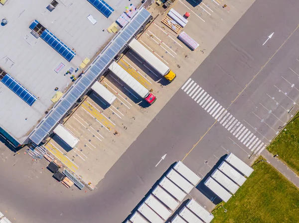 Malzeme deposunun havadan görüntüsü. Sanayi bölgesindeki lojistik merkezi yukarıdan. Lojistik merkezde yüklenen kamyonların hava görüntüsü