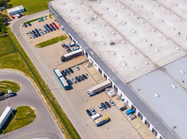 Malzeme deposunun havadan görüntüsü. Sanayi bölgesindeki lojistik merkezi yukarıdan. Lojistik merkezde yüklenen kamyonların hava görüntüsü