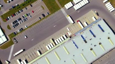 Malzeme deposunun havadan görüntüsü. Sanayi bölgesindeki lojistik merkezi yukarıdan. Lojistik merkezde yüklenen kamyonların hava görüntüsü